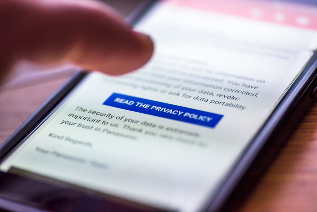 A finger hovers over a button that says “read our privacy policy” on a mobile device screen. 