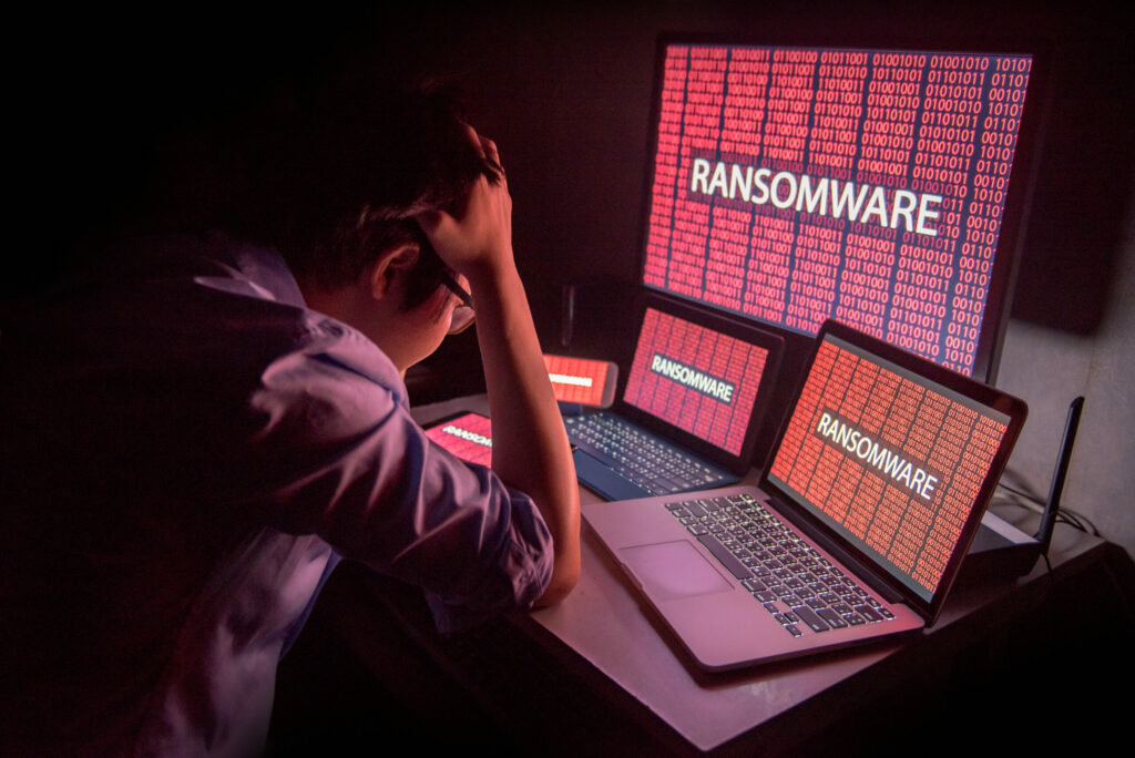 Young man is frustrated after discovering ransomware on his computer devices. 