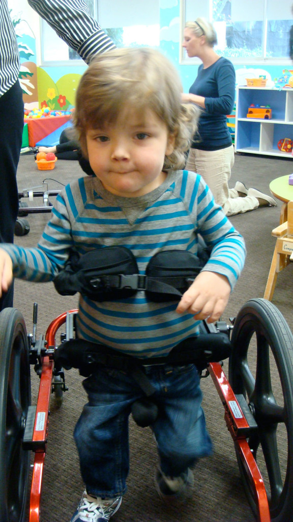Vaughn, the namesake of the Love, Vaughn Foundation, smiles at the camera as he walks in his wheelchair. 