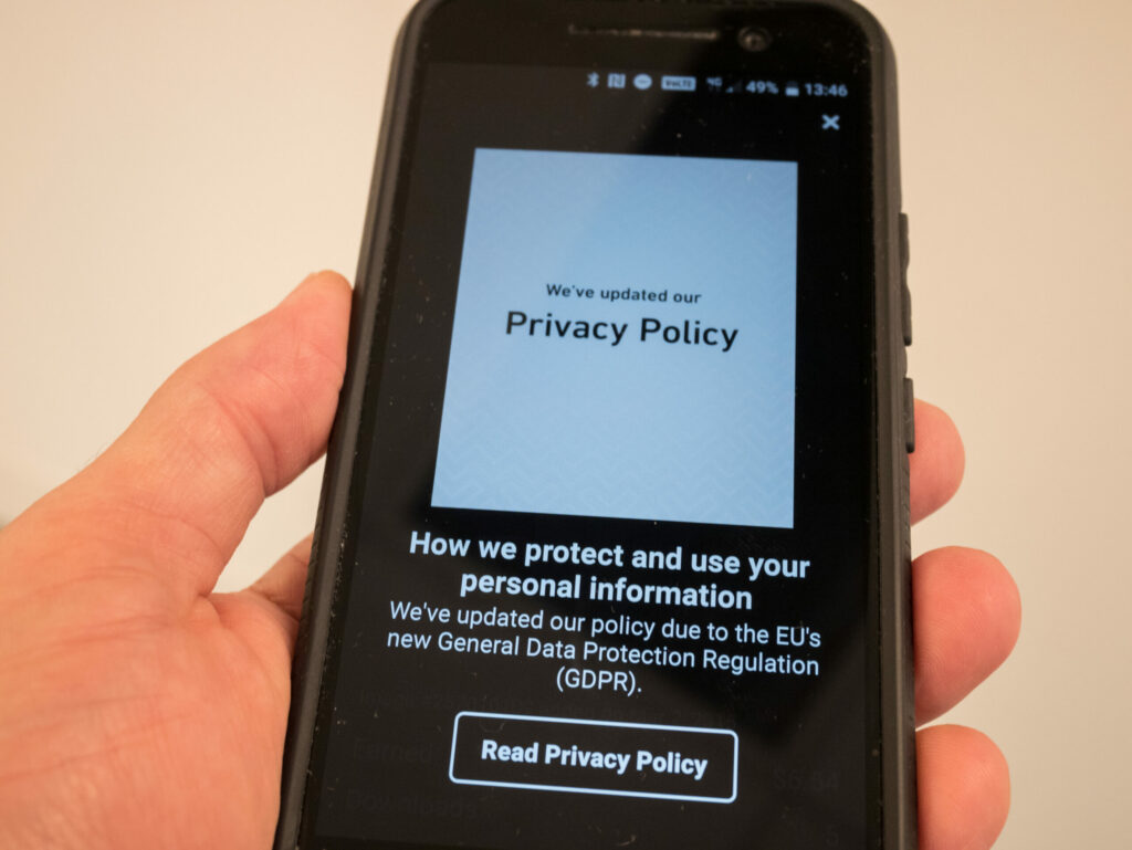 Image of business website displaying GDPR privacy rules via smartphone.