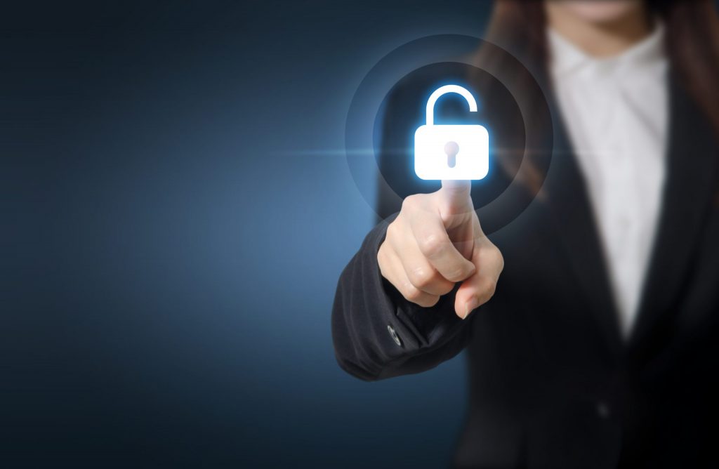 Close up of a female business professional who reaches out to touch a white graphic of a padlock. 