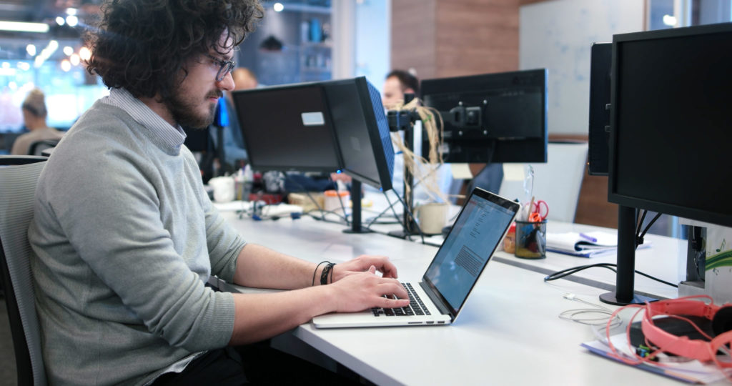 Man working on his laptop at his company office. 