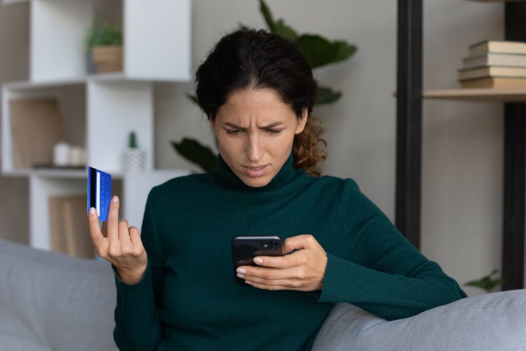 A woman contacts an online retailer on her cell phone upon noticing fraudulent charges on her credit card from a data breach.