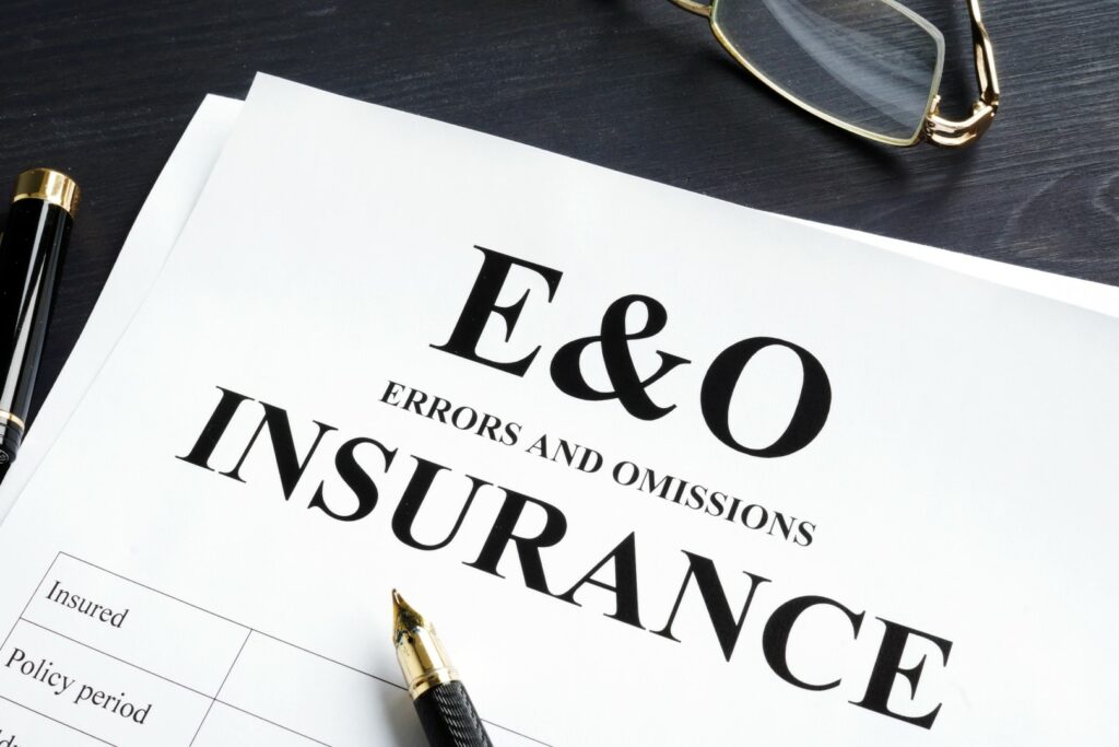 E&O Insurance form on table with fountain pen and eyeglasses.