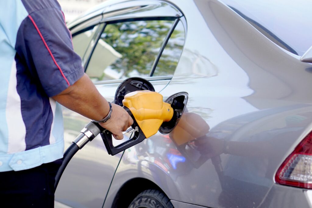Man fuels his car with gasoline. Pumps at gas stations are vulnerable to contingent bodily injury cyber attacks.